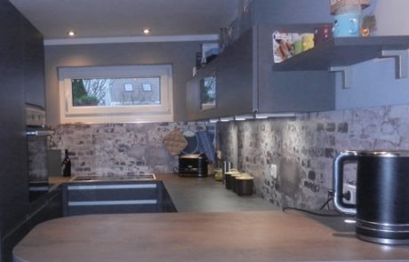 Küchenstudio Ein Bild einer Küche mit grauen Wänden und Arbeitsplatten.