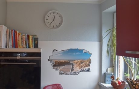 Küchenstudio Eine Küche mit einer Uhr an der Wand und einem Bild an der Wand.