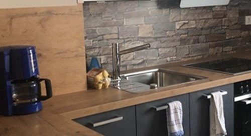 Küchenstudio Eine Küche mit Steinarbeitsplatten und einem Herd, wie in unseren Referenzen zu sehen.