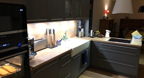 Küchenstudio Referenzen: Eine graue Küche mit Herd und Backofen.