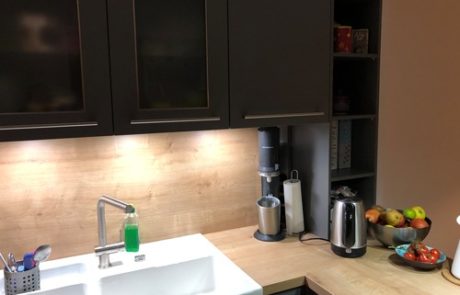 Küchenstudio Eine Referenzen-Küche mit Spüle und Kühlschrank.