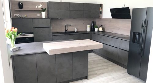 Küchenstudio Eine moderne Küche mit grauen Schränken und schwarzen Geräten, wie in Referenzen abgebildet.