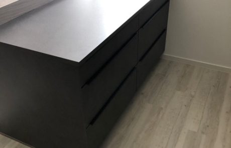 Küchenstudio Eine schwarze Kücheninsel mit Schubladen in einem Raum, perfekt für Referenzen.