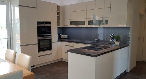 Küchenstudio Eine weiße Küche mit Esstisch und Stühlen, perfekt für Referenzen.