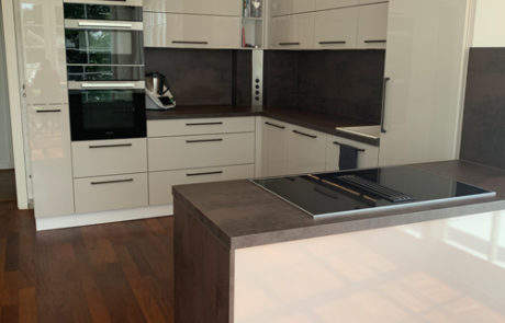 Küchenstudio Eine weiße Küche mit Holzböden, die die Eleganz des Raumes unterstreicht.