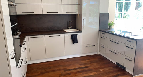 Küchenstudio Referenzen: Eine Küche mit weißen Schränken und Holzböden.
