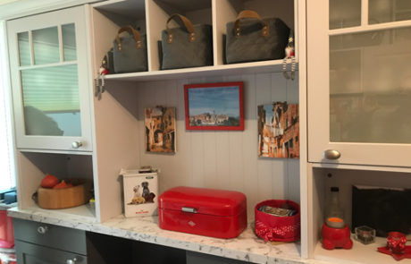 Küchenstudio Eine Küche mit roten und grauen Schränken und Schubladen.