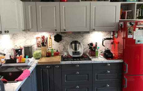 Küchenstudio Eine Küche mit einem rot-grauen Kühlschrank.
