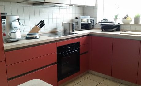 Küchenstudio Referenzen: Eine Küche mit roten Schränken und einem Herd.