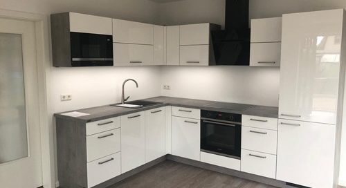 Küchenstudio Eine Küche mit weißen Schränken und einem Herd als Referenz.