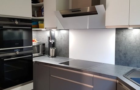 Küchenstudio Eine weiß-graue Küche mit Herd und Backofen, die als Referenz für modernes Design dient.