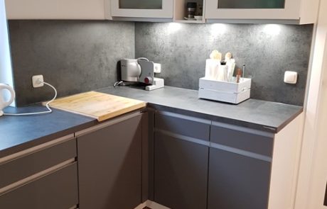 Küchenstudio Eine kleine Küche mit grauen Schränken und einer Spüle, entworfen unter Berücksichtigung von Referenzen.