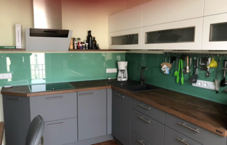 Küchenstudio Referenzen: Eine Küche mit grünen und weißen Schränken und Arbeitsplatten