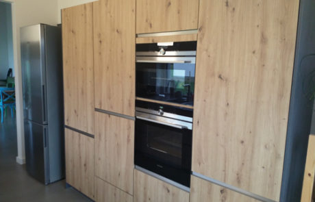 Küchenstudio Referenzen: Eine stilvolle Küche mit Holzschränken und Geräten aus Edelstahl.