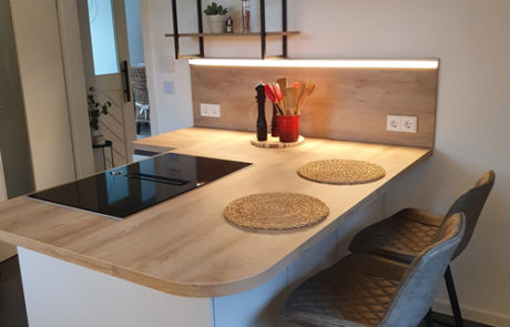 Küchenstudio Eine Küche mit einer Arbeitsplatte aus Holz und Hockern.
