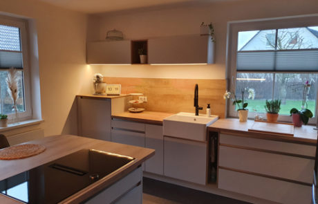 Küchenstudio Eine Küche mit Holzschränken und einem Waschbecken.
