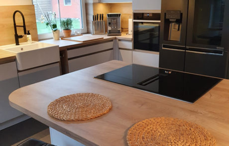 Küchenstudio Eine moderne Küche mit einer Arbeitsplatte aus Holz und Küchengeräten aus Edelstahl.