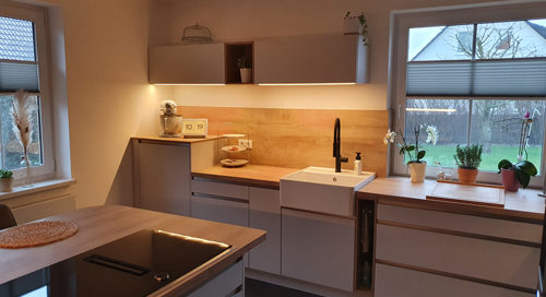 Küchenstudio Eine Küche mit Holzschränken und einem Waschbecken.