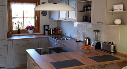 Küchenstudio Eine Küche mit einem Holztisch und Stühlen.