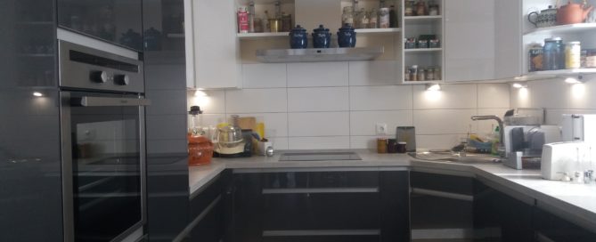 Küchenstudio Eine schwarz-weiße Küche mit Herd und Backofen.