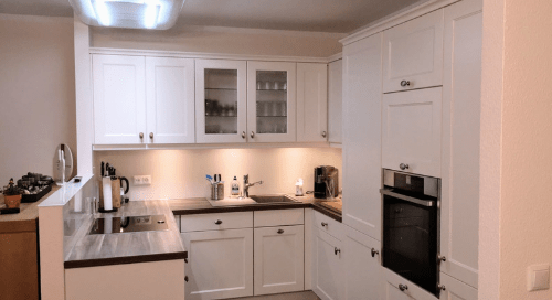 Küchenstudio Eine weiße Küche mit Herd und Backofen.