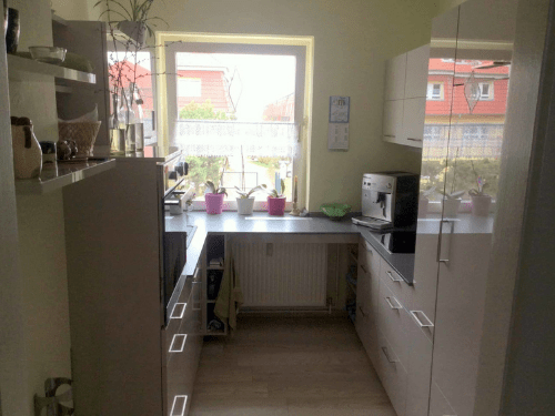 Küchenstudio Eine kleine Küche mit Fenster und Herd.