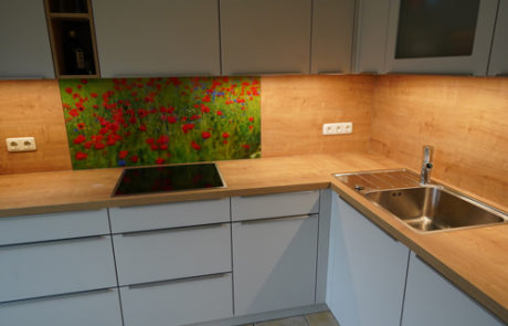 Küchenstudio Eine Küche mit Glasrückwand und Spüle.