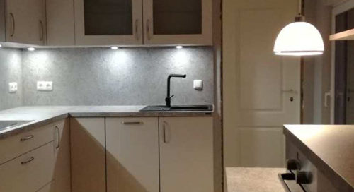 Küchenstudio Eine kleine Küche mit weißen Schränken und einem Waschbecken.