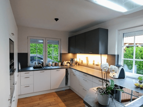 Küchenstudio Ein Bild einer Küche mit weißen Schränken und schwarzen Arbeitsplatten.
