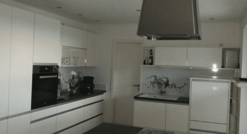 Küchenstudio Eine Küche mit weißen Schränken und einem Tisch.