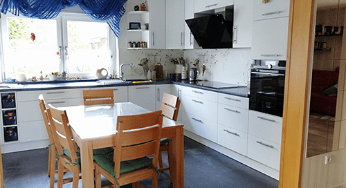 Küchenstudio Eine Küche mit Tisch und Stühlen.