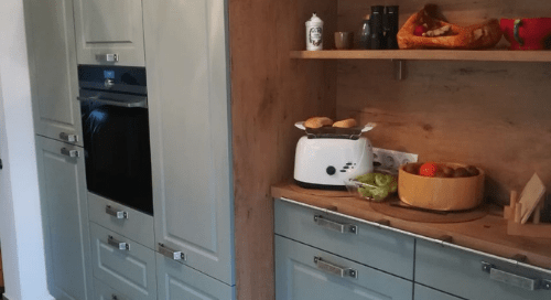 Küchenstudio Eine Küche mit blauen Schränken und einer Arbeitsplatte aus Holz.