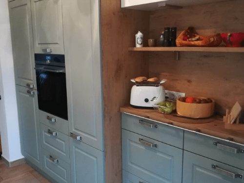 Küchenstudio Eine Küche mit blauen Schränken und einer Arbeitsplatte aus Holz.
