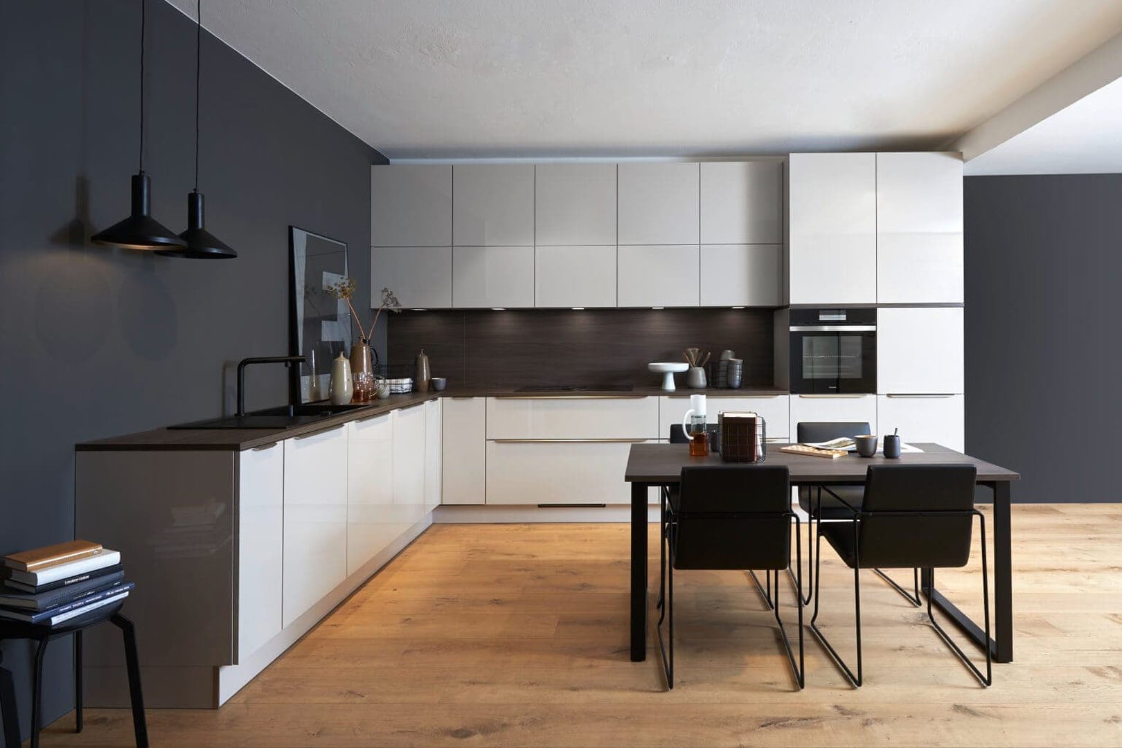 Küchenstudio Eine moderne Küche mit weißen Schränken und Holzböden.