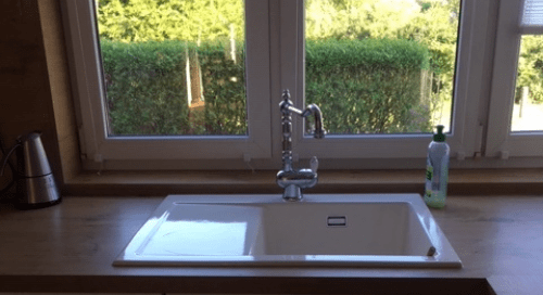 Küchenstudio Ein Waschbecken in einer Küche neben einem Fenster.