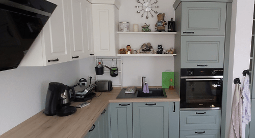 Küchenstudio Eine Küche mit blauen und weißen Schränken und einem Herd.