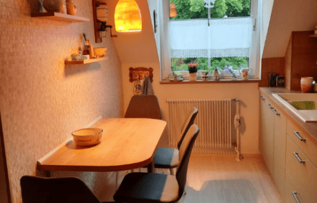 Küchenstudio Eine kleine Küche mit Tisch und Stühlen.