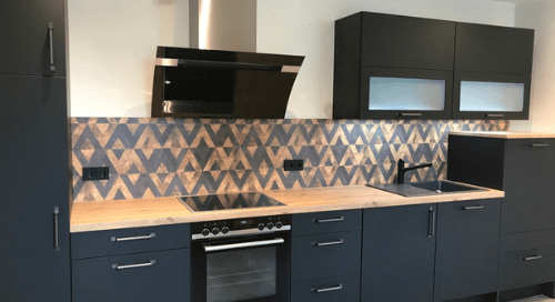 Küchenstudio Eine Küche mit schwarzen Schränken und einem Herd.