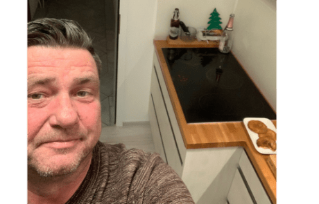 Küchenstudio Ein Mann macht ein Selfie in seiner Küche.