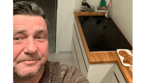 Küchenstudio Ein Mann macht ein Selfie in seiner Küche.