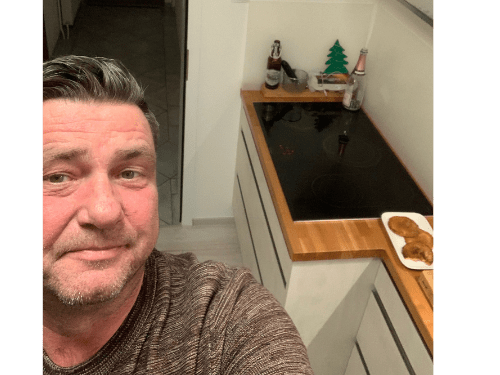 Küchenstudio Ein Mann macht ein Selfie in seiner Küche.