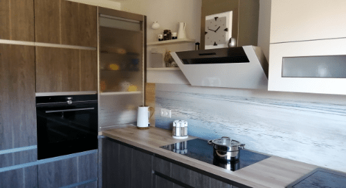 Küchenstudio Eine Küche mit Holzschränken und einem Herd.