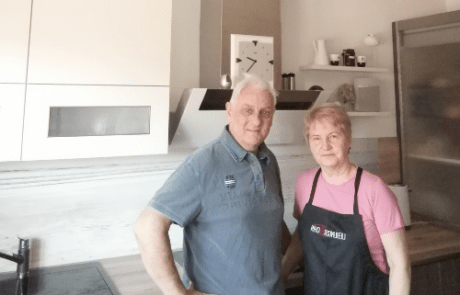 Küchenstudio Ein Mann und eine Frau stehen vor einer Küche.