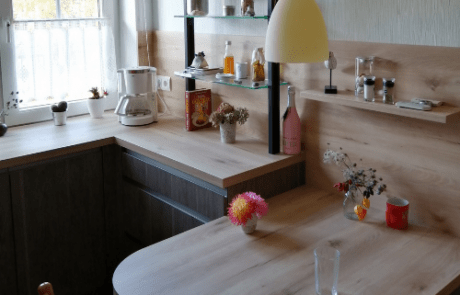 Küchenstudio Eine kleine Küche mit einem Holztisch und Stühlen.