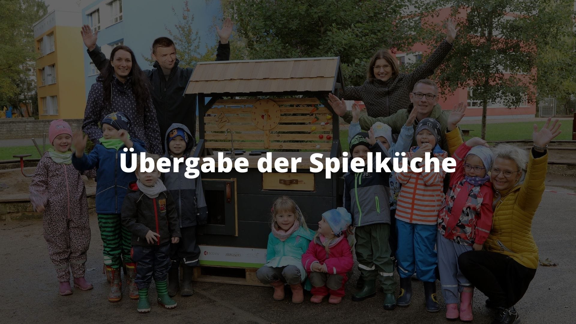 Küchenstudio Eine Gruppe von Menschen posiert vor einem Holzhaus.