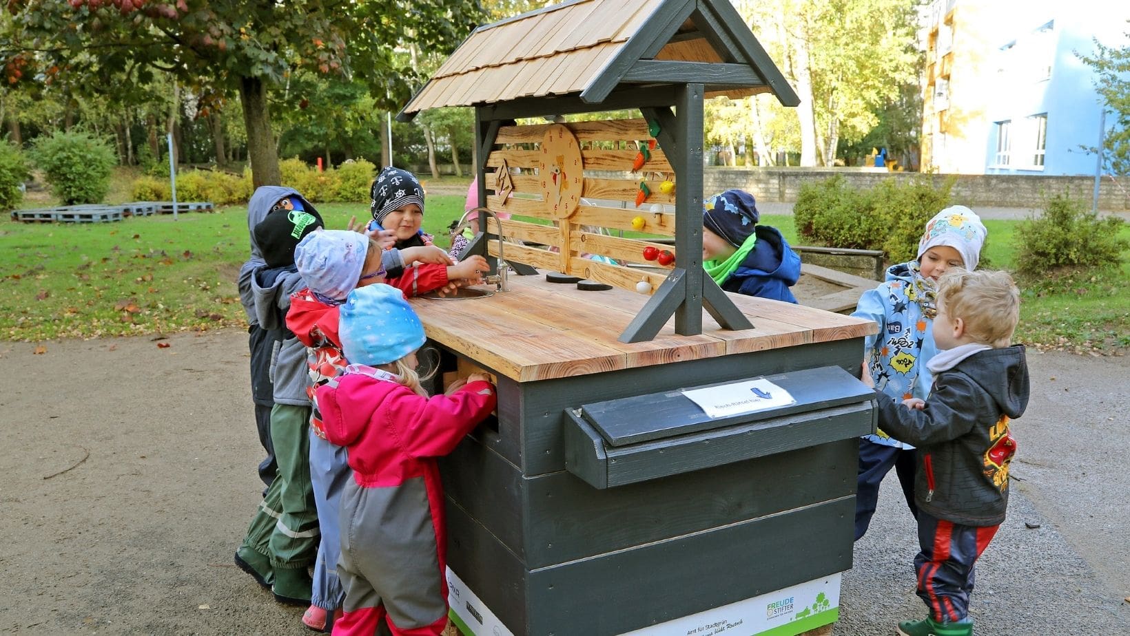 Küchenstudio Eine Gruppe Kinder steht um eine Holzkiste.