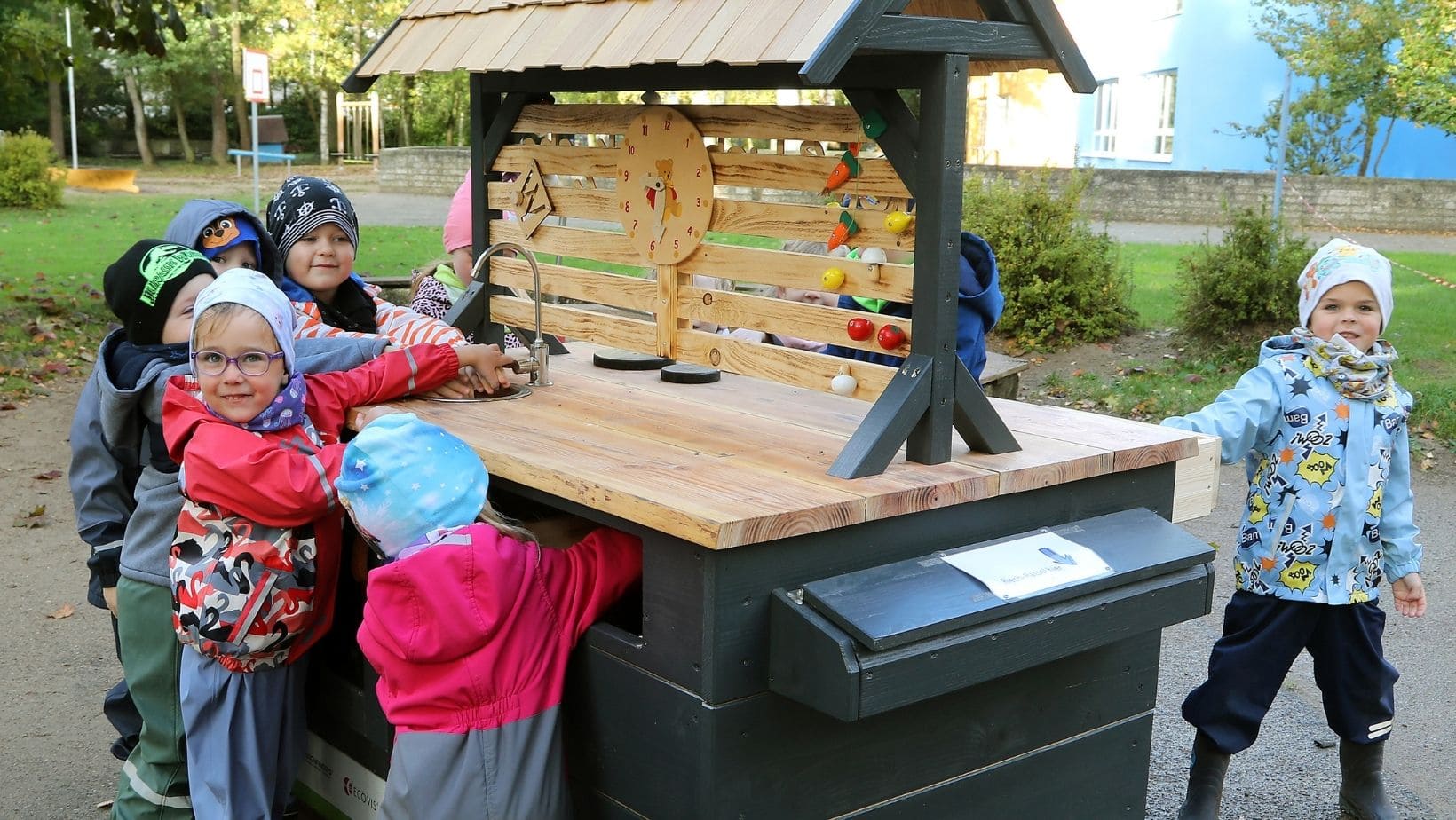 Küchenstudio Eine Gruppe Kinder steht um einen Holztisch.