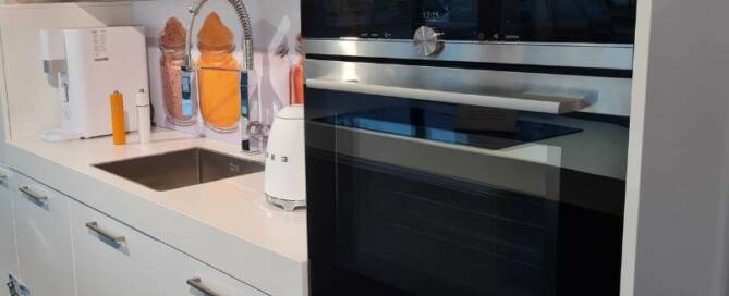 Küchenstudio Eine weiße Küche mit Abverkauf und Backofen.