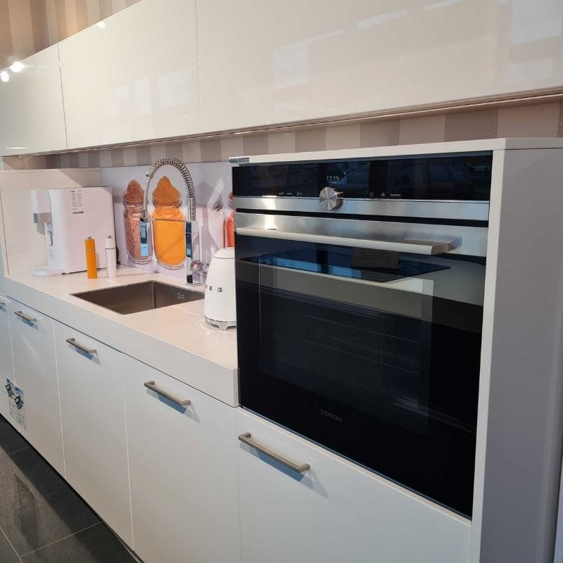 Küchenstudio Eine weiße Küche mit Abverkauf und Backofen.