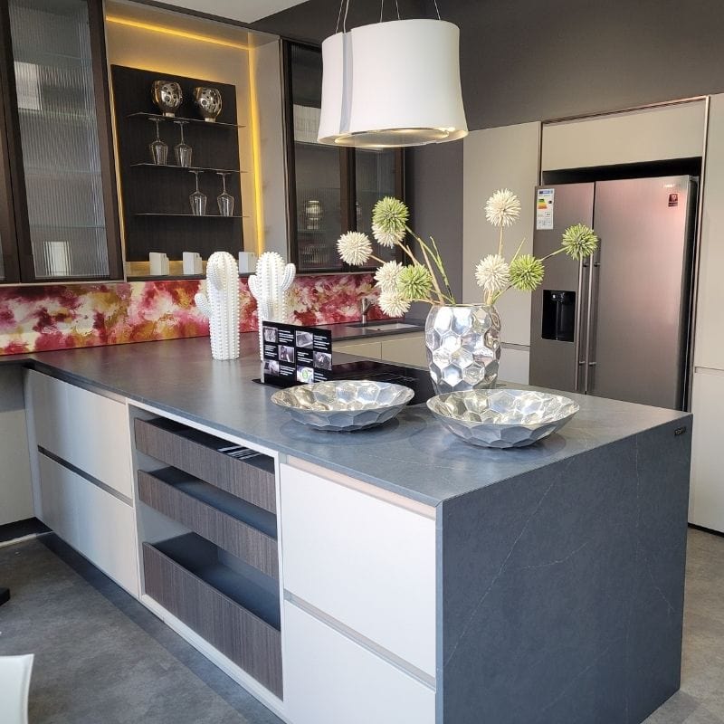 Küchenstudio Eine moderne Küche mit einer grauen Insel und weißen Schränken zum Abverkauf verfügbar.